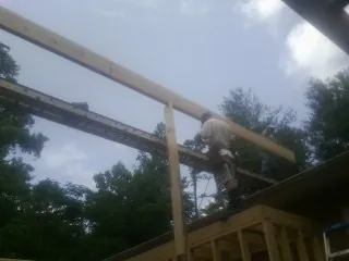 Carpenter setting a ridge beam over a new addition frame — Ice Dam Removal by Roofing Brothers in Maria Stein