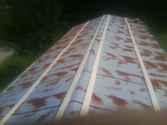Rusted metal roof panels with new wood purlins before replacement — Storm Damage Roof Repair in Maria Stein by Roofing Brothers