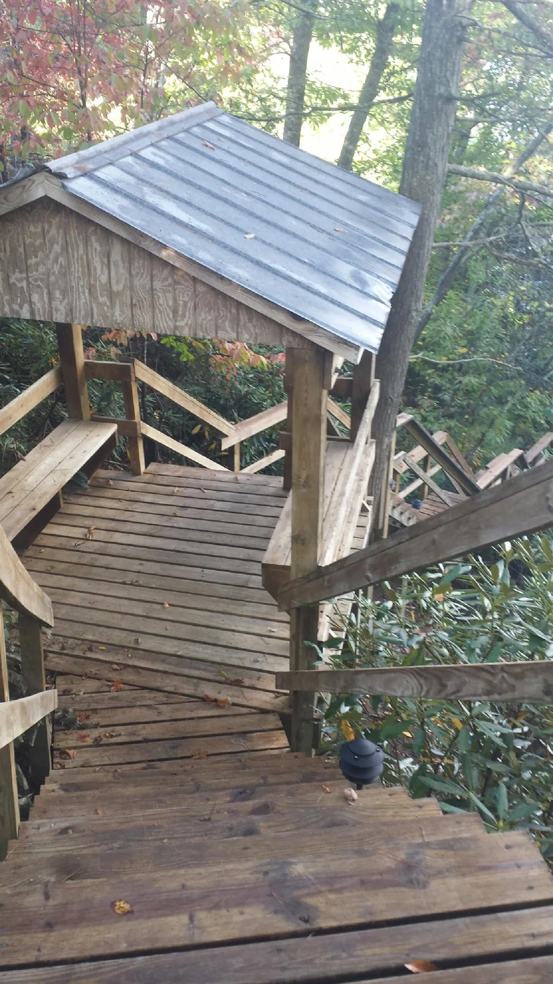 Metal roofed shelter over wooden steps on a wooded walkway — Skylight Repair & Installation work by our crew in Maria Stein