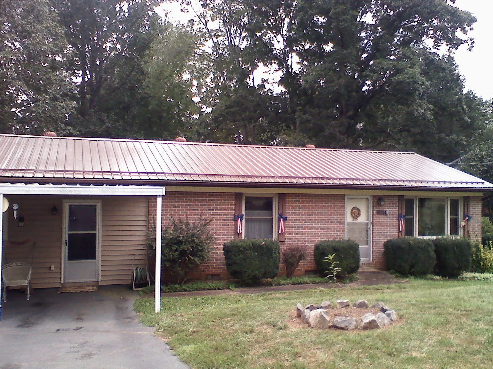 Bronze metal roof and carport on a brick ranch home — Roof Repair work by our crew in Maria Stein